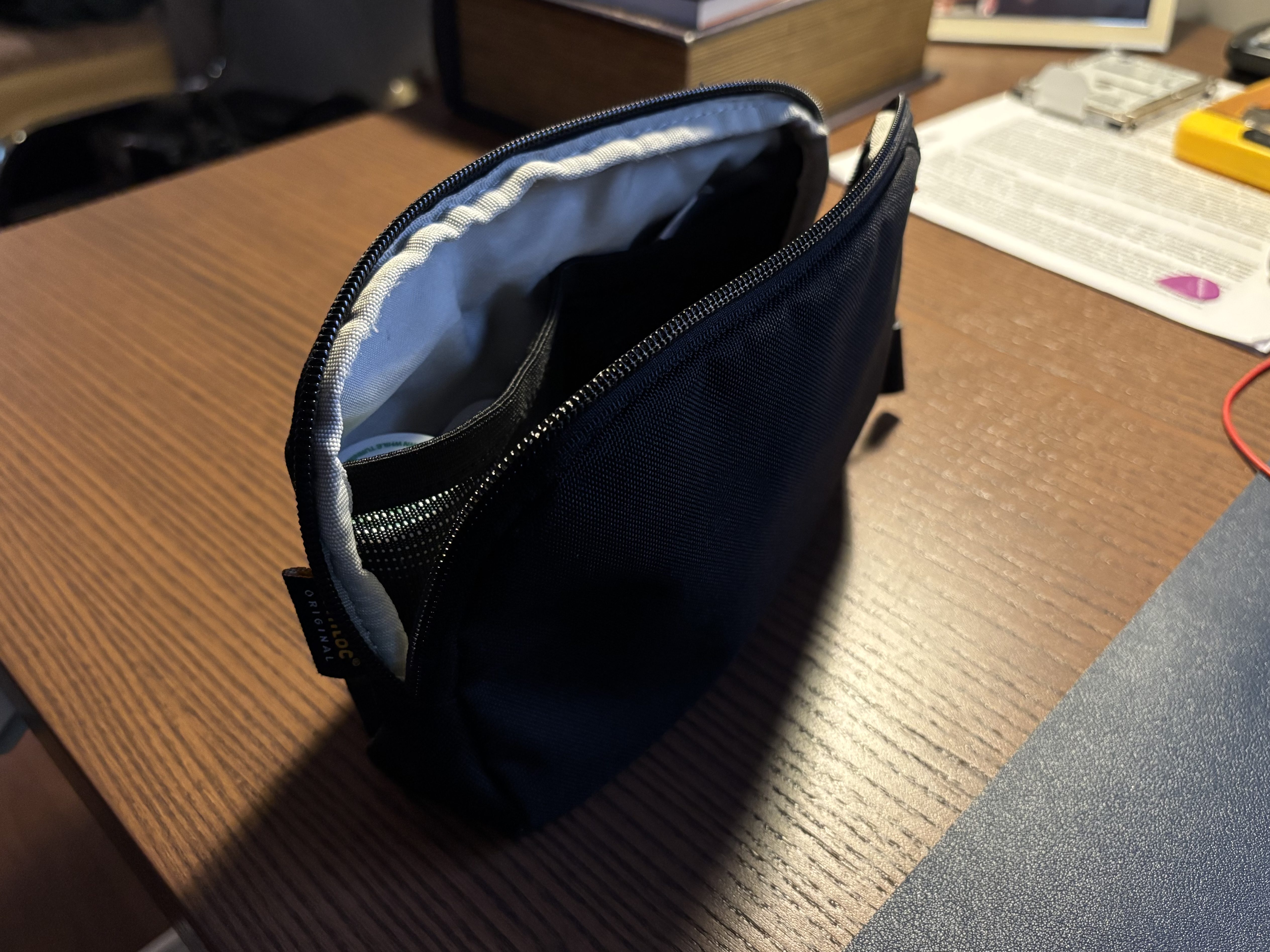 Image of a small black carrying case with the zipper open.
